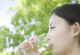 Frau trinkt Wasser aus einem Glas
